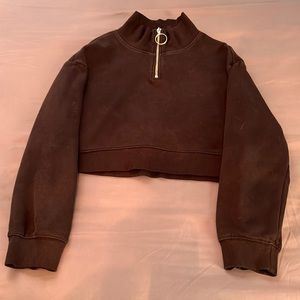 A Black cropped sweatshirt with turtleneck neckline that has a zipper from H&M.